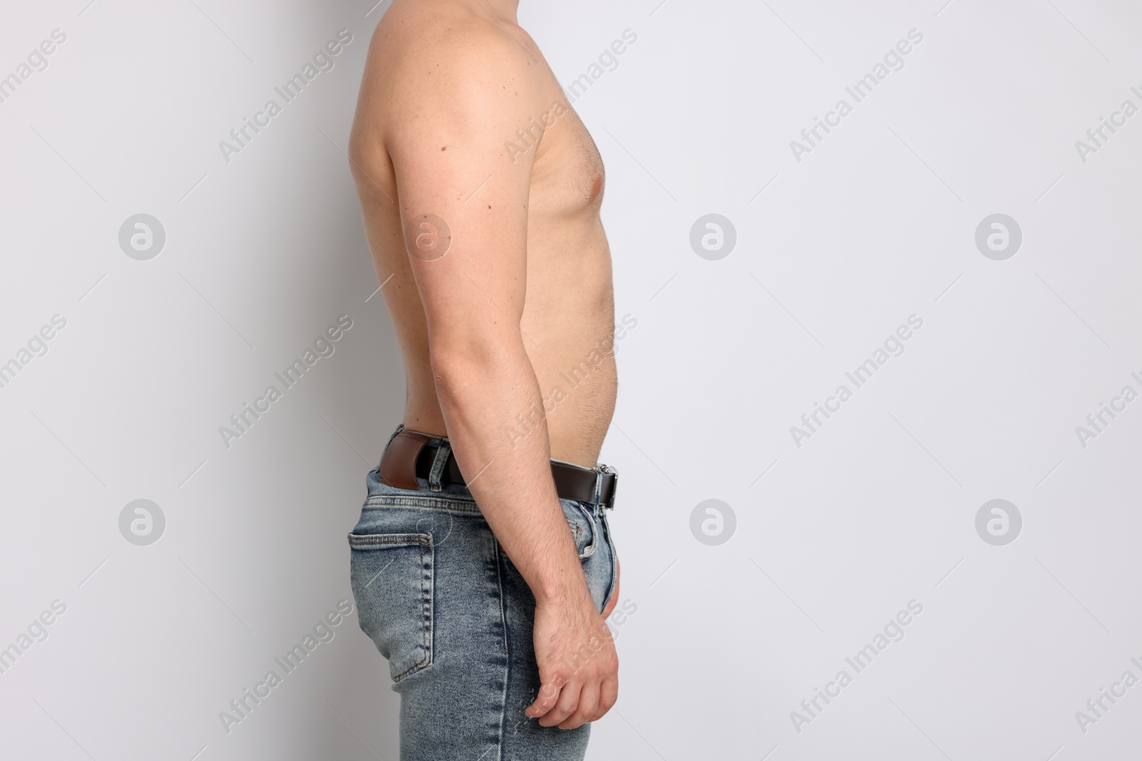Man after weight loss on light background, closeup Photo of Man after weight loss on light background, closeup