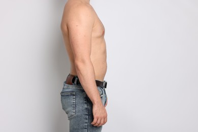 Photo of Man after weight loss on light background, closeup