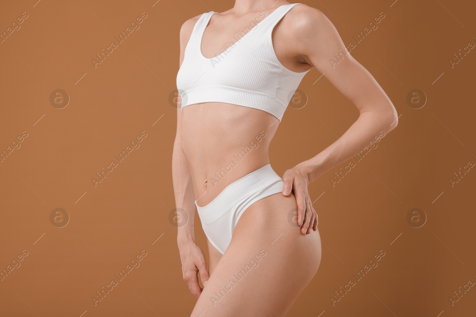 Woman with perfect slim body on beige background, closeup Photo of Woman with perfect slim body on beige background, closeup