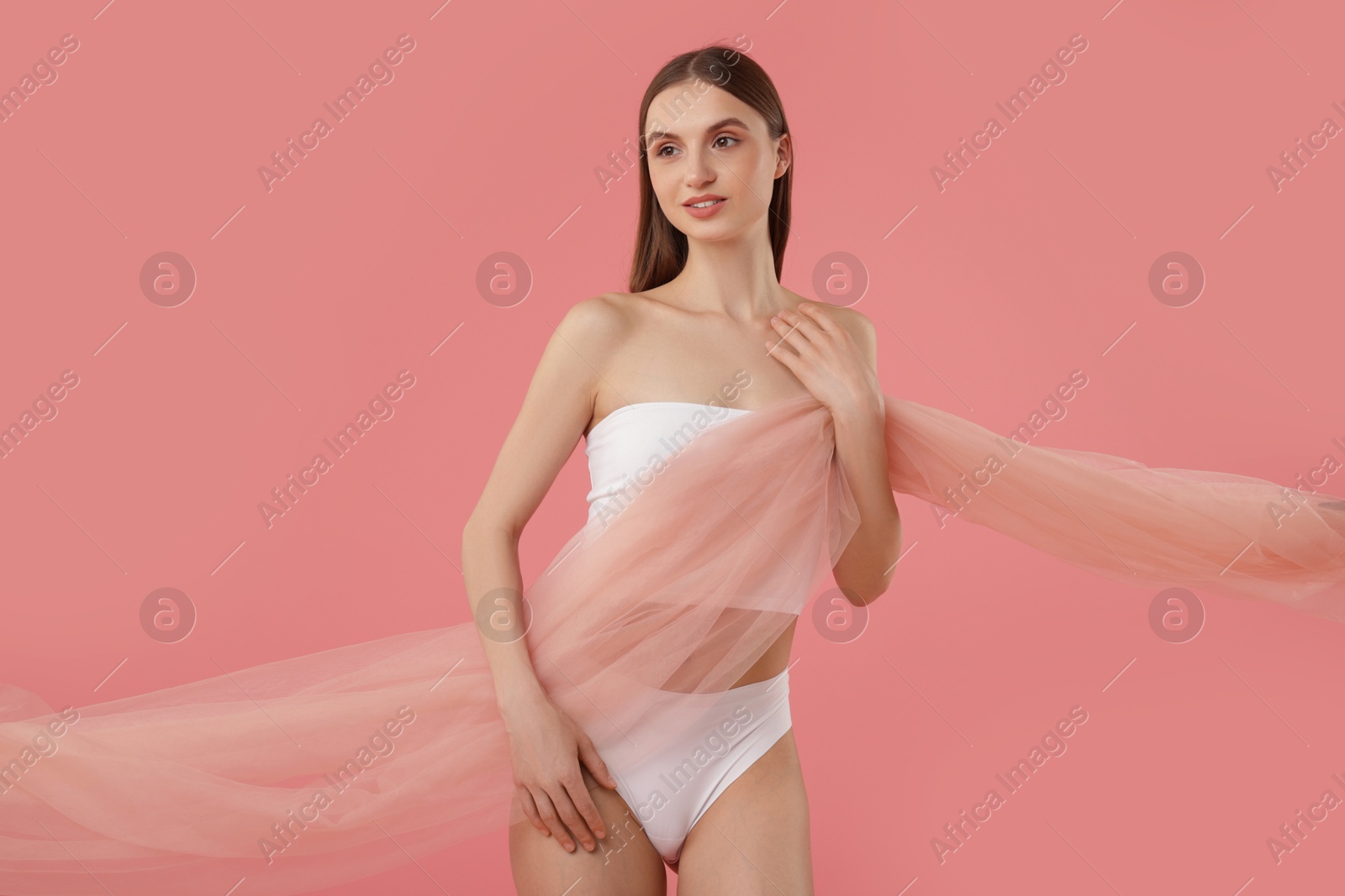 Young woman with beautiful fabric on pink background Photo of Young woman with beautiful fabric on pink background