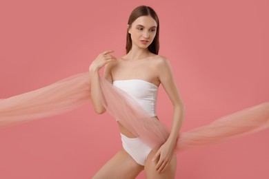 Photo of Young woman with beautiful fabric on pink background