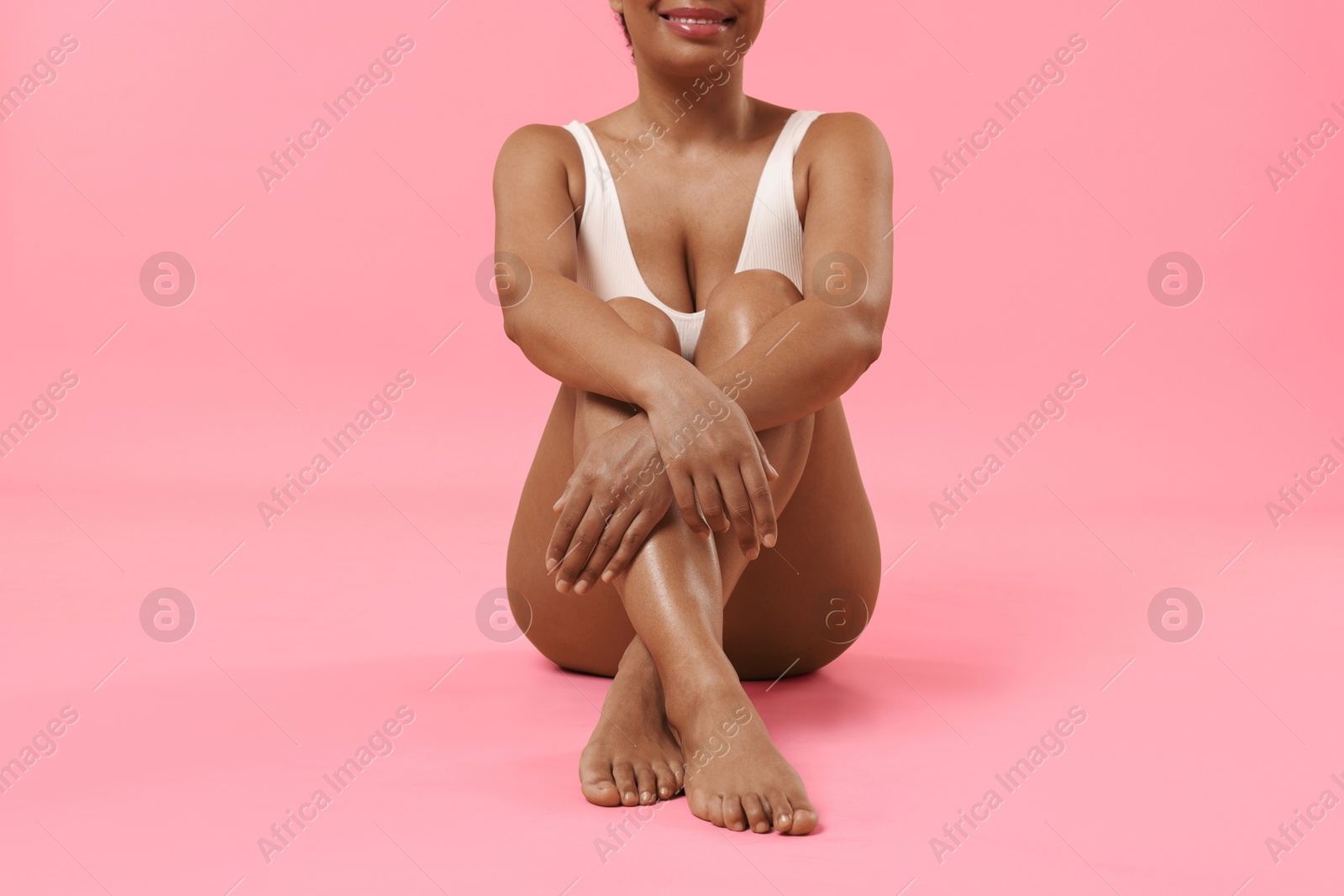 Woman in white underwear with smooth skin after epilation procedure on pink background, closeup Photo of Woman in white underwear with smooth skin after epilation procedure on pink background, closeup