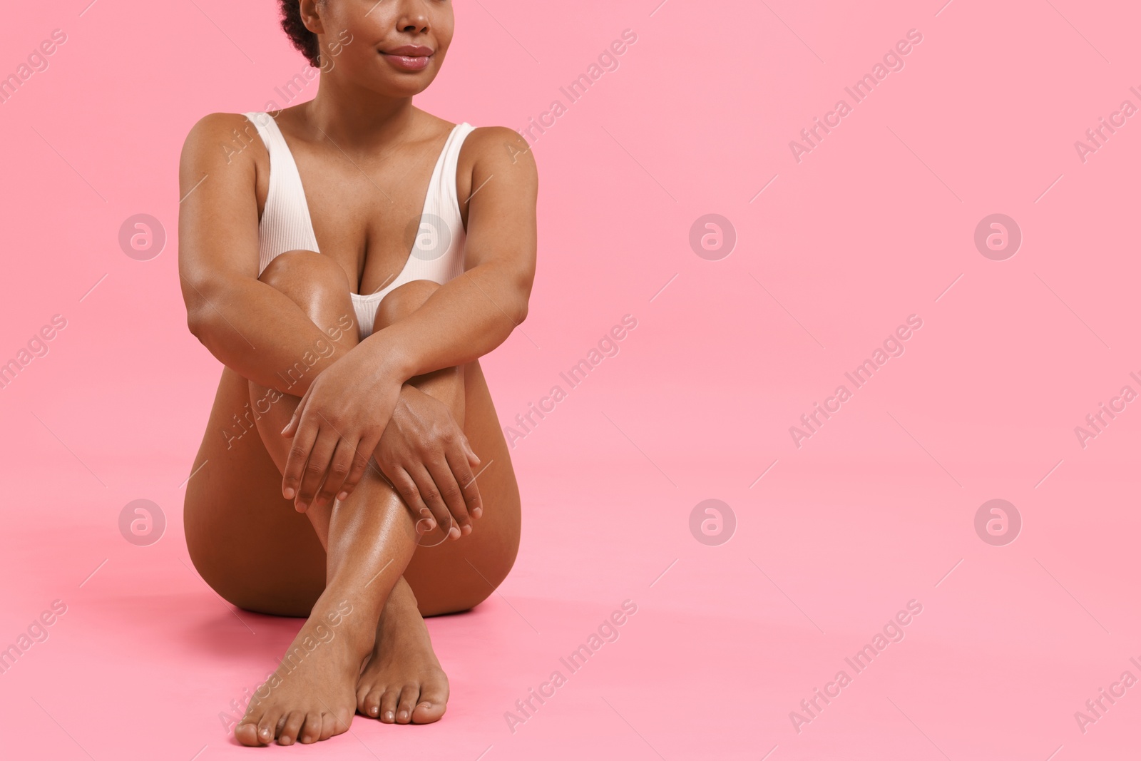 Woman in white underwear with smooth skin after epilation procedure on pink background, closeup. Space for text Photo of Woman in white underwear with smooth skin after epilation procedure on pink background, closeup. Space for text