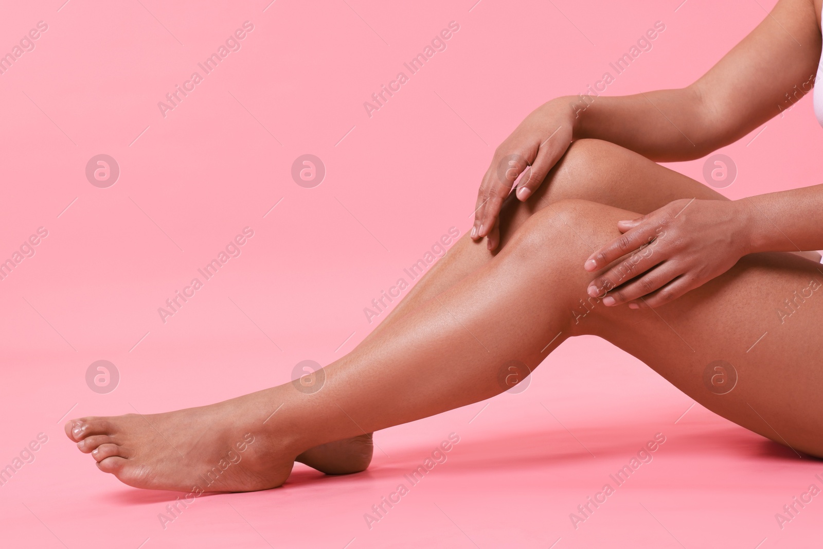 Epilation. Woman showing her legs with smooth soft skin on pink background, closeup Photo of Epilation. Woman showing her legs with smooth soft skin on pink background, closeup