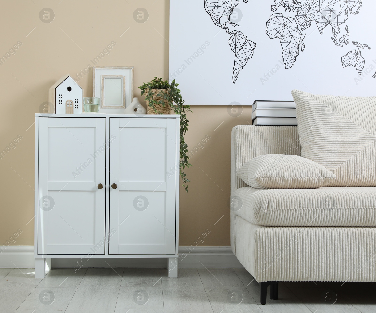 Dresser with stylish decor and houseplant near beige wall indoors Photo of Dresser with stylish decor and houseplant near beige wall indoors