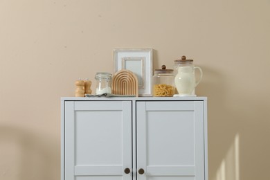 Photo of Dresser with stylish decor near beige wall indoors