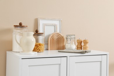 Photo of Dresser with stylish decor near beige wall indoors