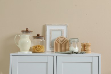 Photo of Dresser with stylish decor near beige wall indoors