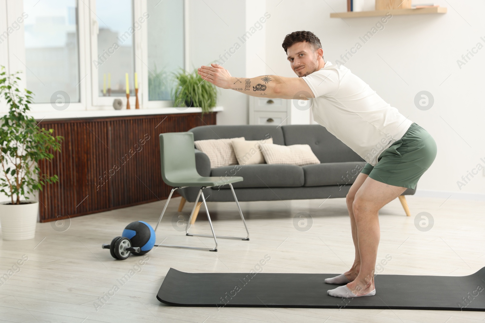Handsome man exercising on fitness mat at home Photo of Handsome man exercising on fitness mat at home