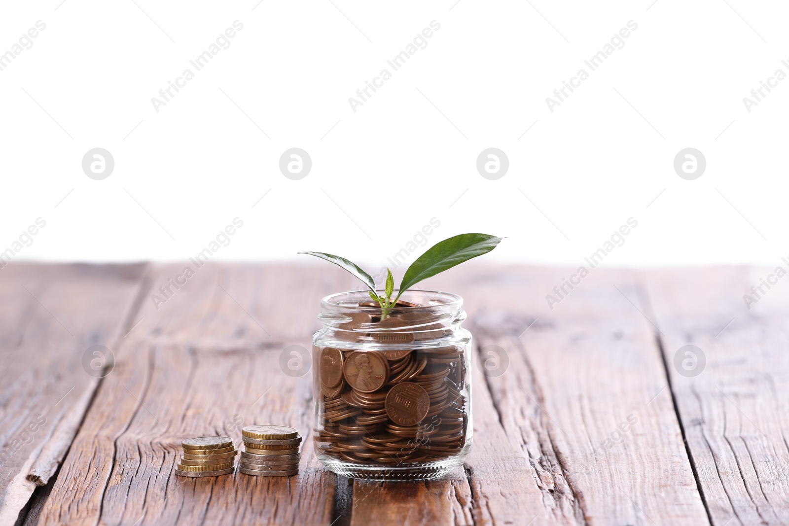 Investment concept. Glass jar with coins and sprout on wooden table against light background Photo of Investment concept. Glass jar with coins and sprout on wooden table against light background