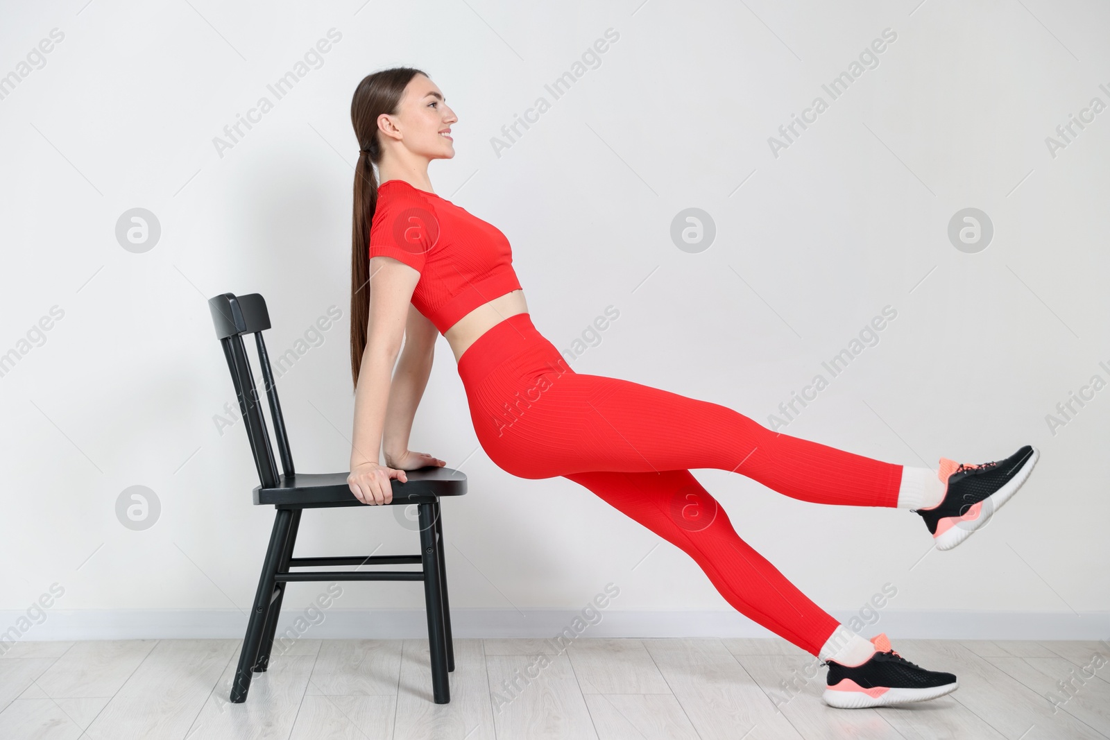 Beautiful woman exercising with chair at home Photo of Beautiful woman exercising with chair at home