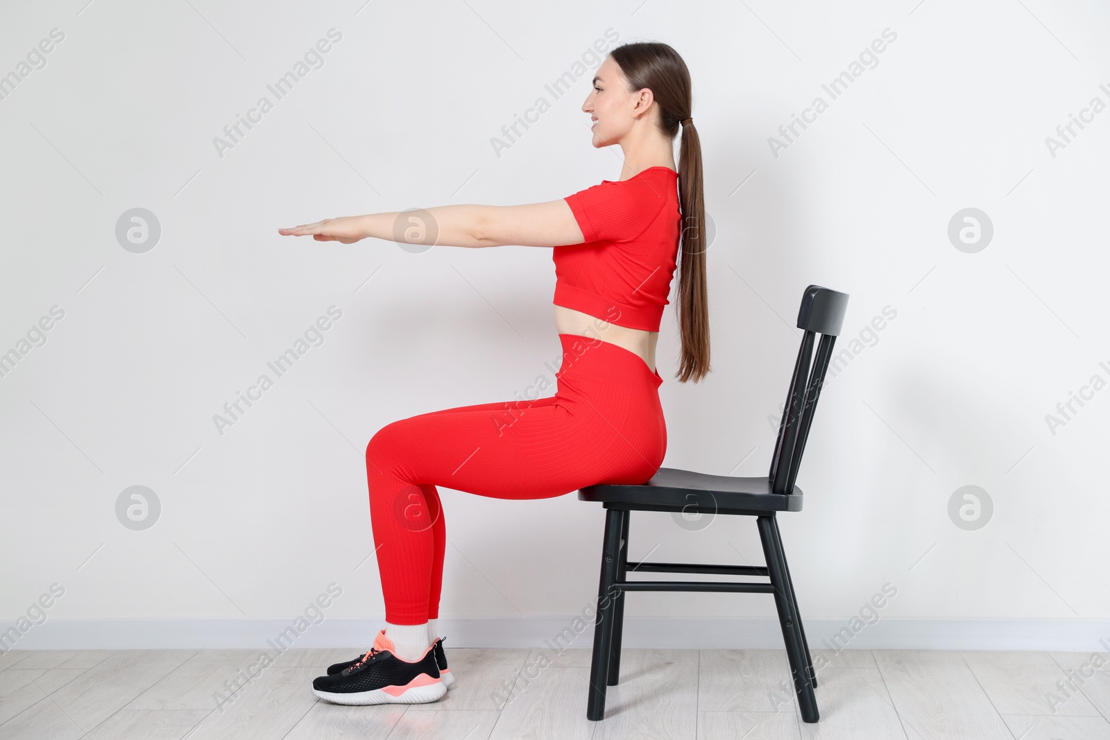Beautiful woman stretching on chair at home Photo of Beautiful woman stretching on chair at home