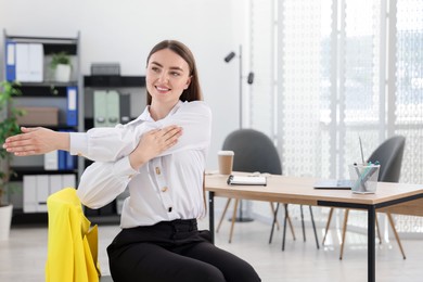 Photo of Beautiful woman stretching on chair in office