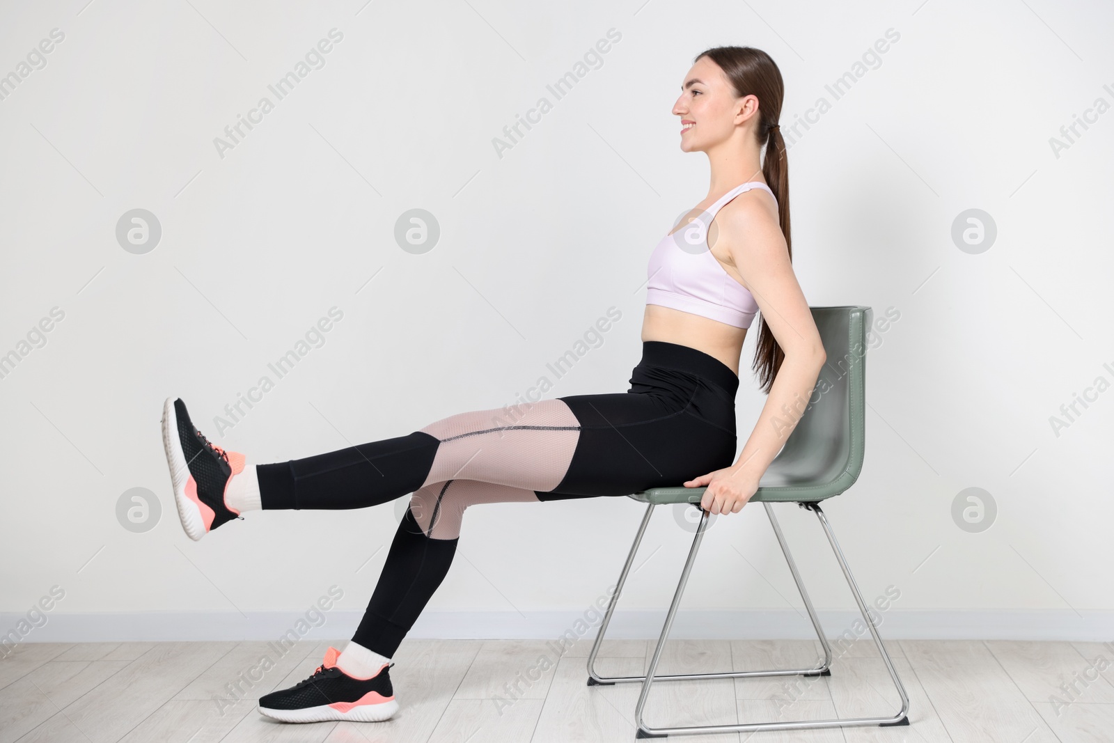 Beautiful woman exercising with chair at home Photo of Beautiful woman exercising with chair at home