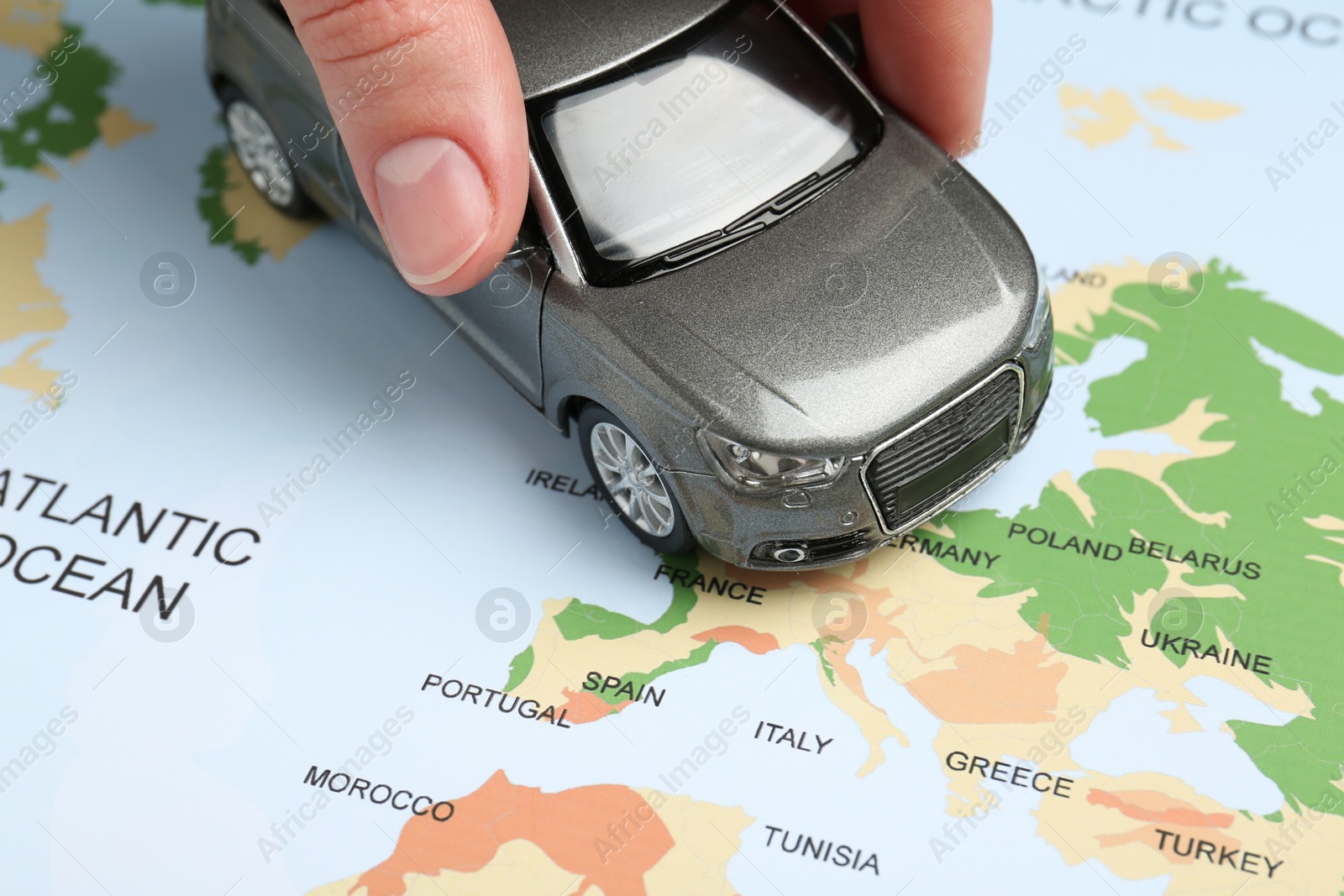 Road trip concept. Woman moving car model on world map, closeup Photo of Road trip concept. Woman moving car model on world map, closeup
