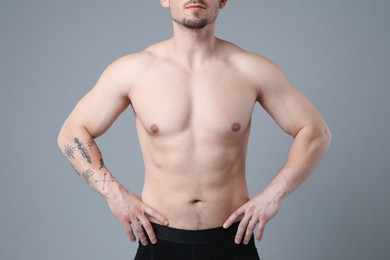 Photo of Young man with smooth chest after epilation procedure on light grey background, closeup
