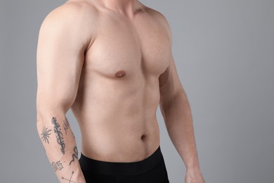 Photo of Young man with smooth chest after epilation procedure on light grey background, closeup