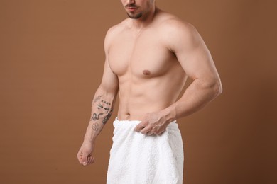 Photo of Young man with smooth chest after epilation procedure on brown background, closeup