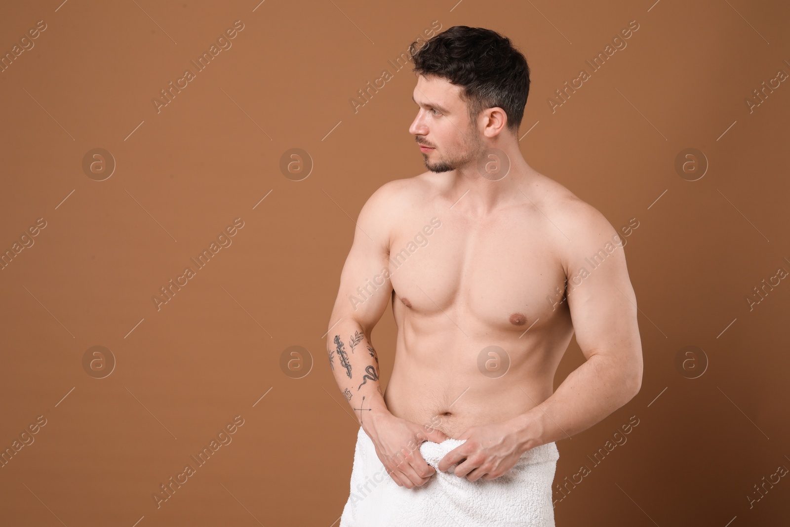 Young man with smooth chest after epilation procedure on brown background Photo of Young man with smooth chest after epilation procedure on brown background