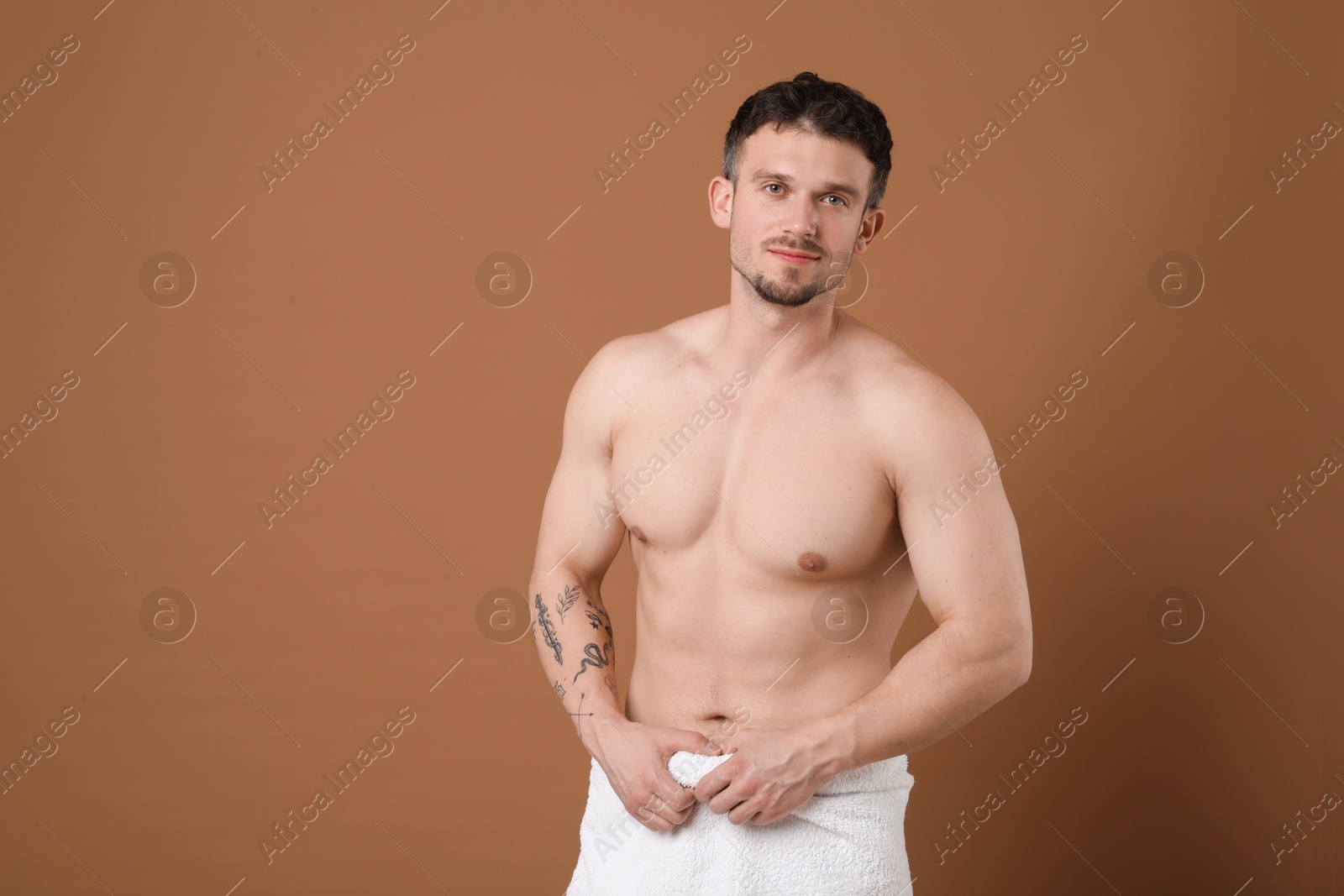 Young man with smooth chest after epilation procedure on brown background Photo of Young man with smooth chest after epilation procedure on brown background