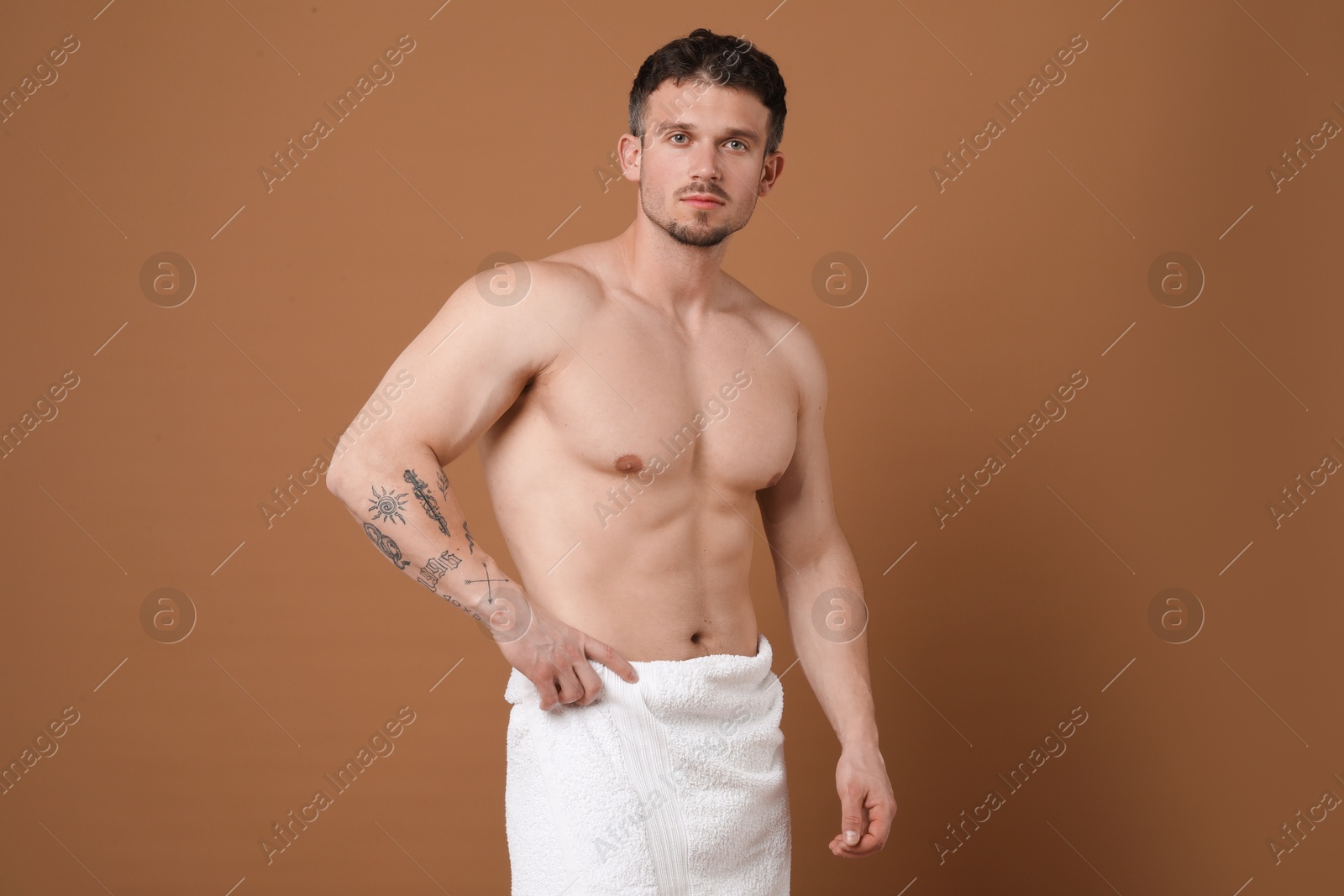 Young man with smooth chest after epilation procedure on brown background Photo of Young man with smooth chest after epilation procedure on brown background