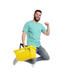 Photo of Man with empty shopping basket jumping on white background