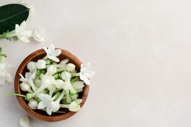 Photo of Bowl with jasmine flowers on beige table, flat lay. Space for text
