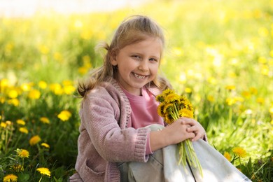 Photo of Cute little girl with beautiful dandelions outdoors on sunny day
