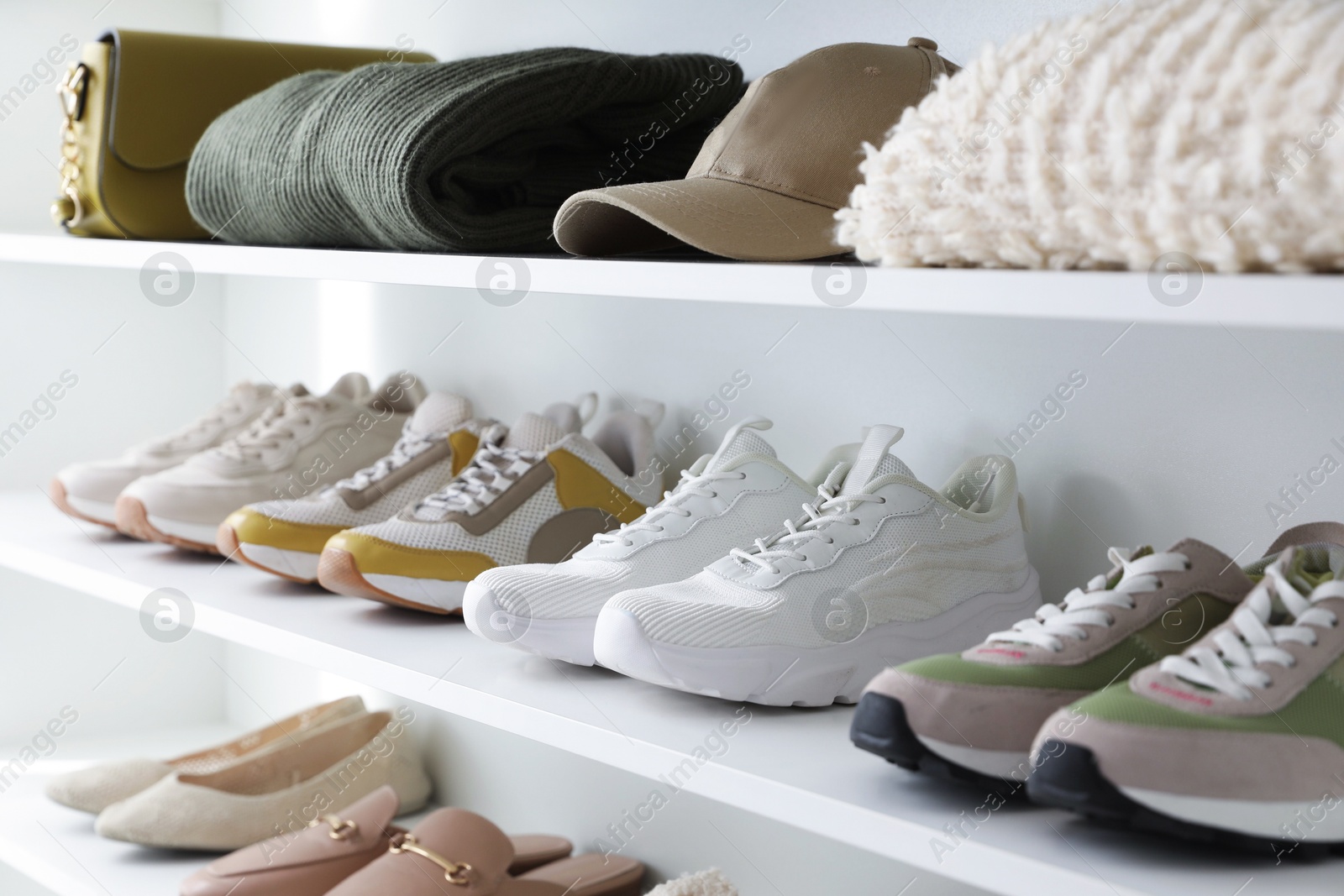 Different footwear, clothes and accessories on shelves indoors, closeup. Shoe storage Photo of Different footwear, clothes and accessories on shelves indoors, closeup. Shoe storage