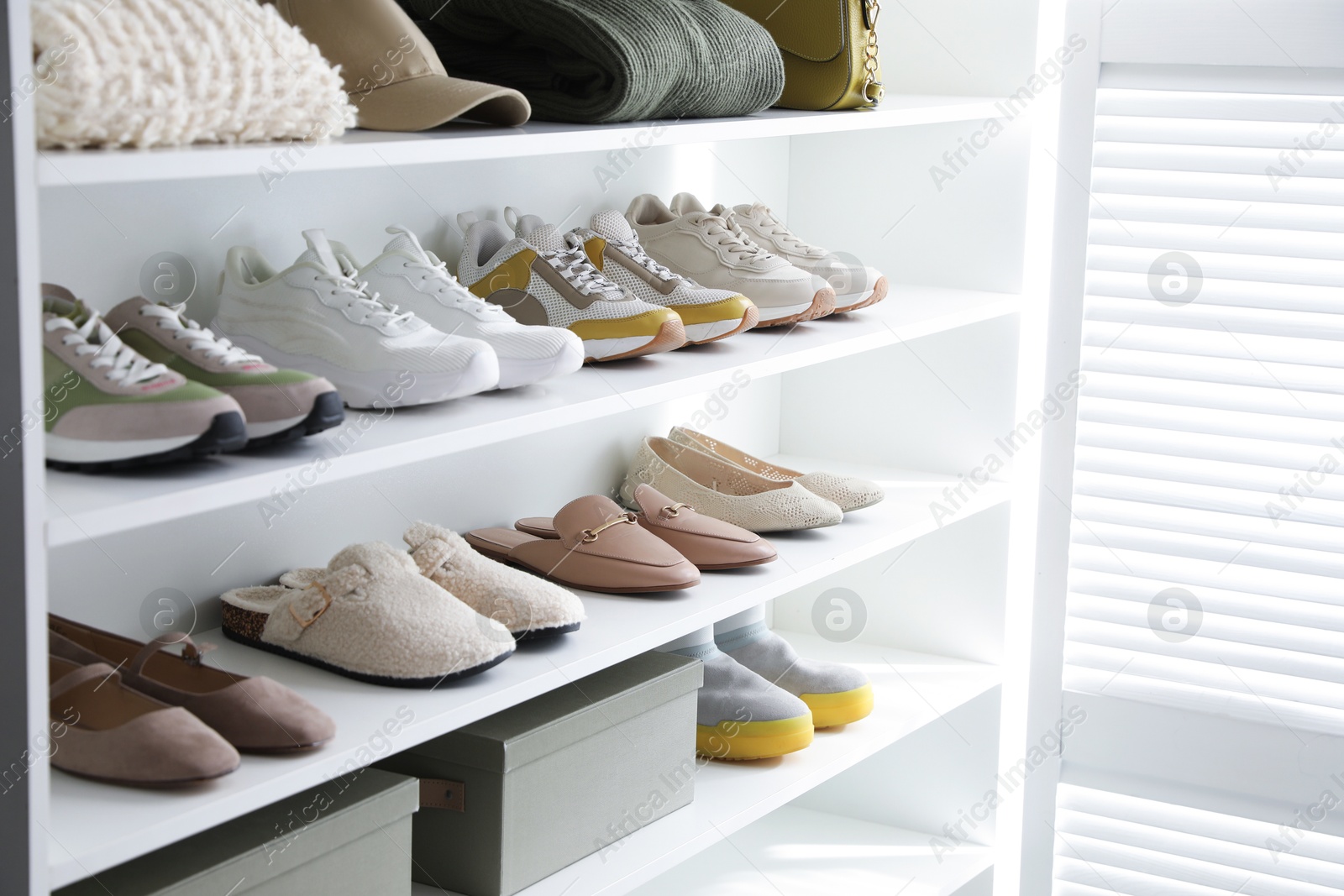 Different footwear, clothes and accessories on shelves indoors, closeup. Shoe storage Photo of Different footwear, clothes and accessories on shelves indoors, closeup. Shoe storage