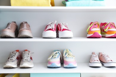 Photo of Different footwear on shelves indoors. Shoe storage