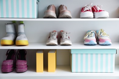Photo of Different footwear on shelves indoors. Shoe storage
