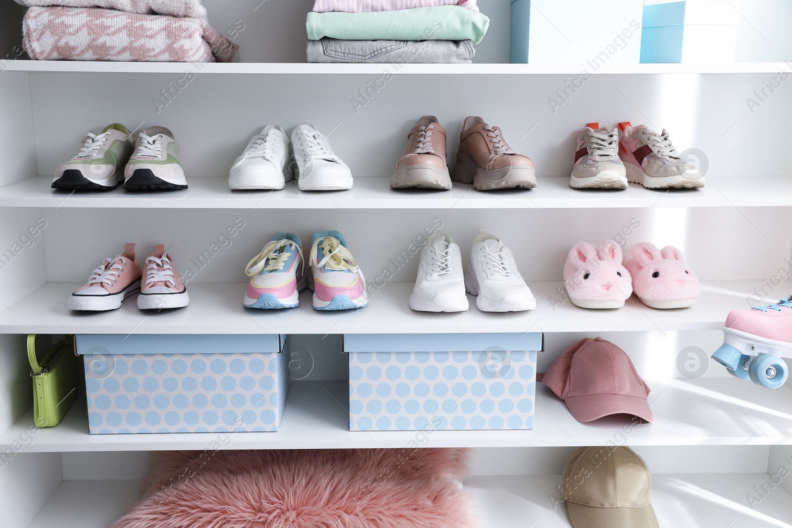 Different footwear, accessories and clothes on shelves indoors. Shoe storage Photo of Different footwear, accessories and clothes on shelves indoors. Shoe storage
