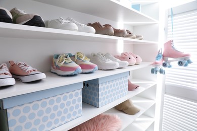 Photo of Different footwear and accessories on shelves indoors, closeup. Shoe storage