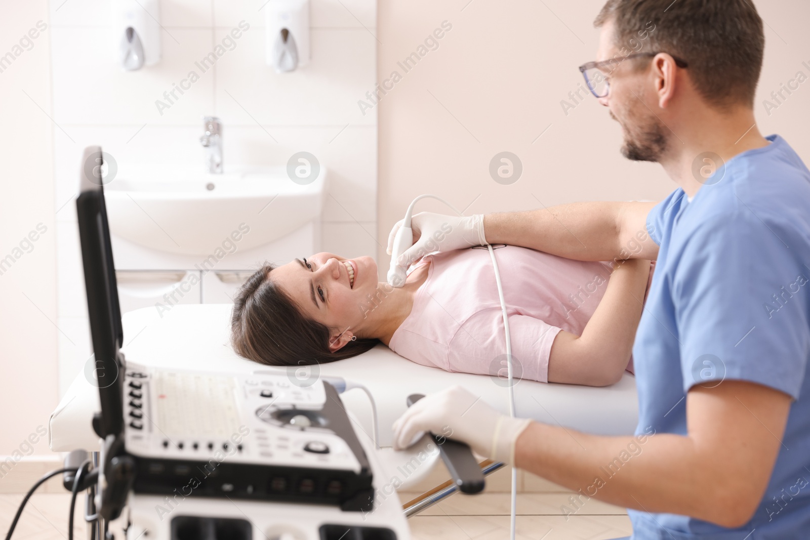 Sonographer conducting ultrasound examination of woman's thyroid gland in clinic Photo of Sonographer conducting ultrasound examination of woman's thyroid gland in clinic