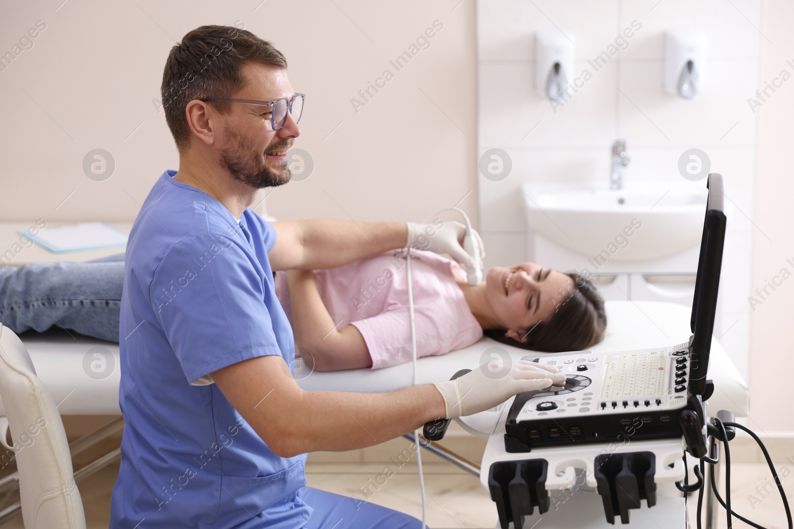 Sonographer conducting ultrasound examination of woman's thyroid gland in clinic Photo of Sonographer conducting ultrasound examination of woman's thyroid gland in clinic