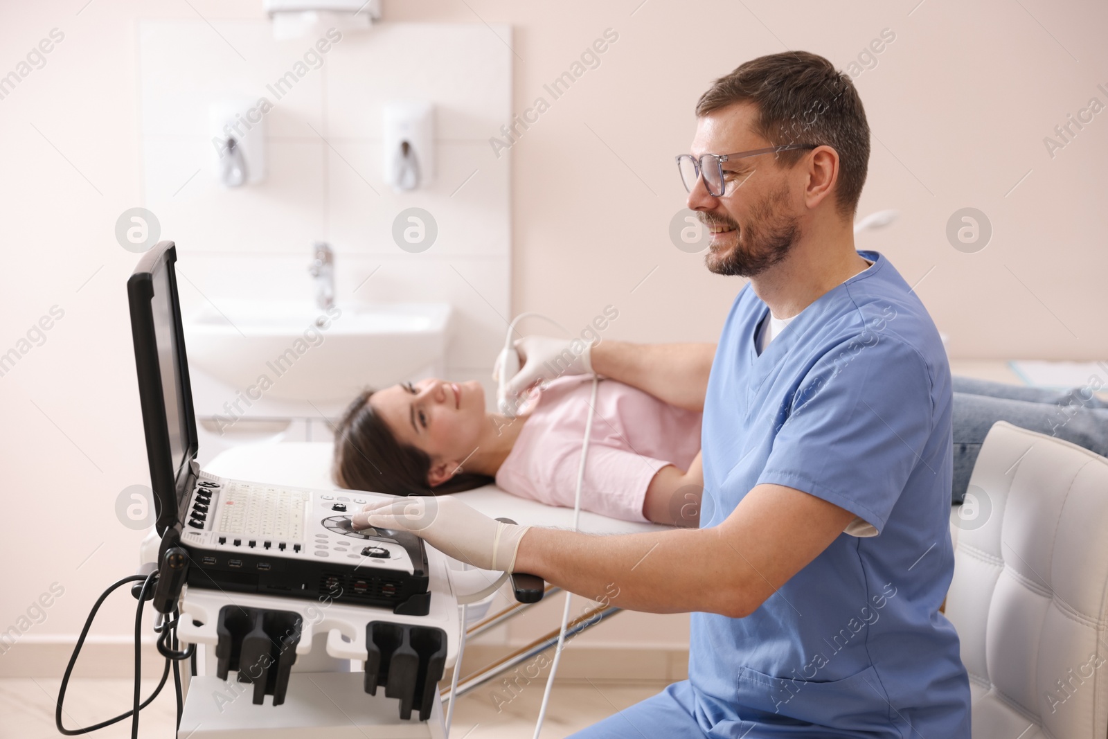 Sonographer conducting ultrasound examination of woman's thyroid gland in clinic Photo of Sonographer conducting ultrasound examination of woman's thyroid gland in clinic