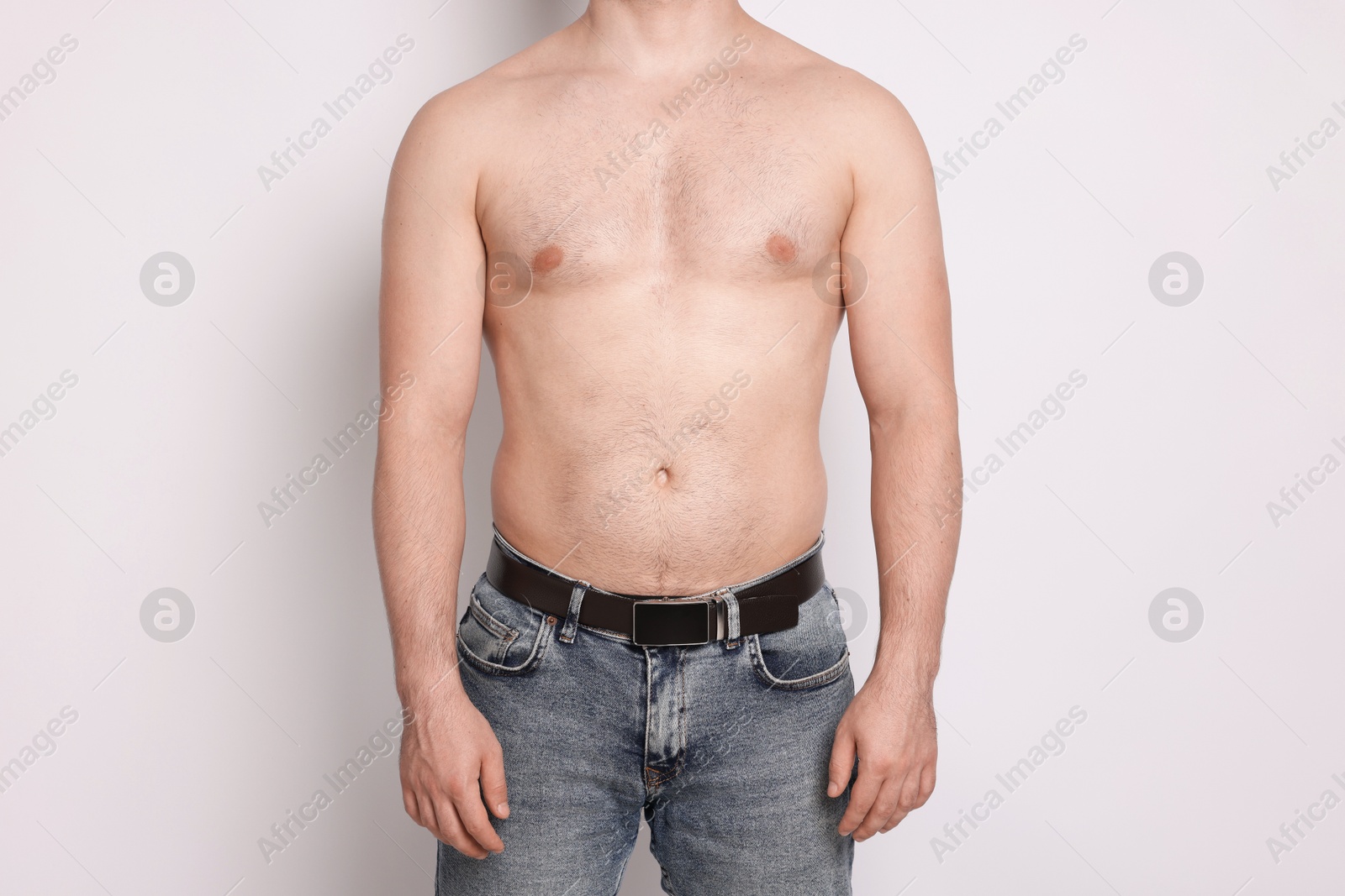 Man after weight loss on light background, closeup Photo of Man after weight loss on light background, closeup
