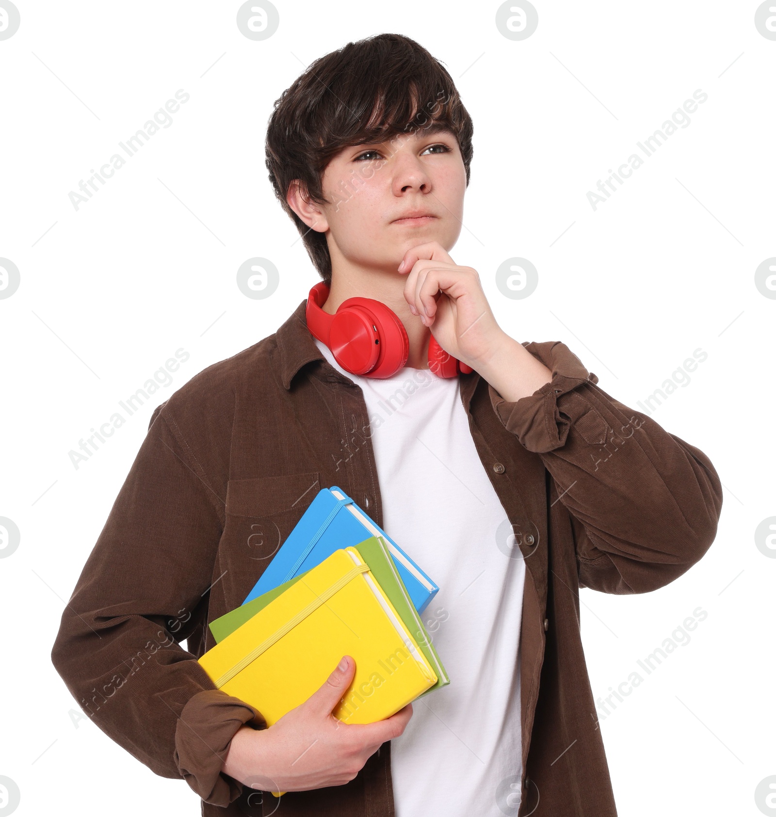 Teenage boy with headphones and notebooks on white background Photo of Teenage boy with headphones and notebooks on white background