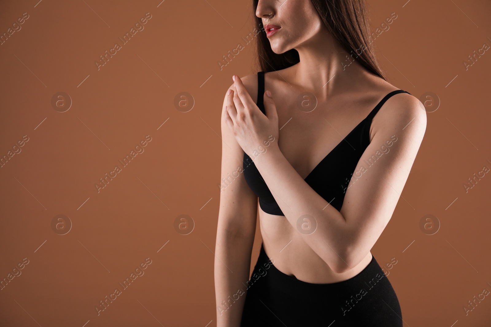 Woman with beautiful collarbone on brown background, closeup. Space for text Photo of Woman with beautiful collarbone on brown background, closeup. Space for text