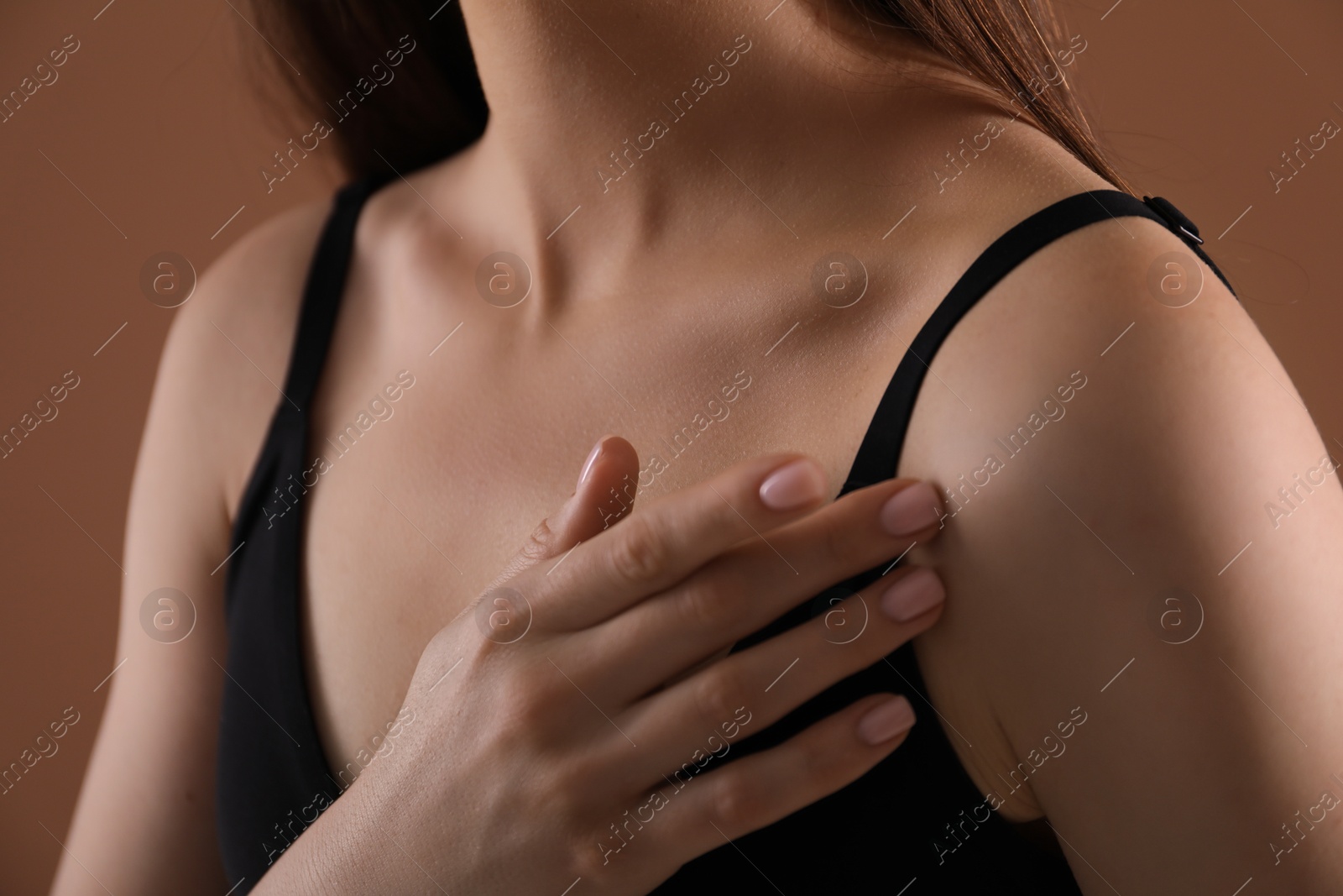 Woman with beautiful collarbone on brown background, closeup Photo of Woman with beautiful collarbone on brown background, closeup