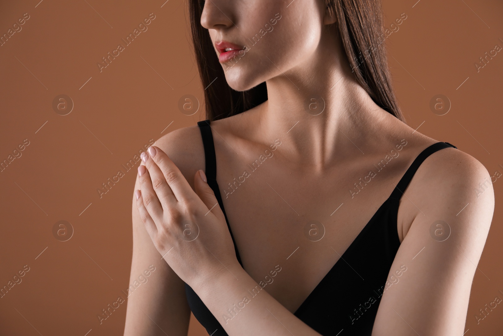 Woman with beautiful collarbone on brown background, closeup Photo of Woman with beautiful collarbone on brown background, closeup