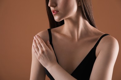 Photo of Woman with beautiful collarbone on brown background, closeup