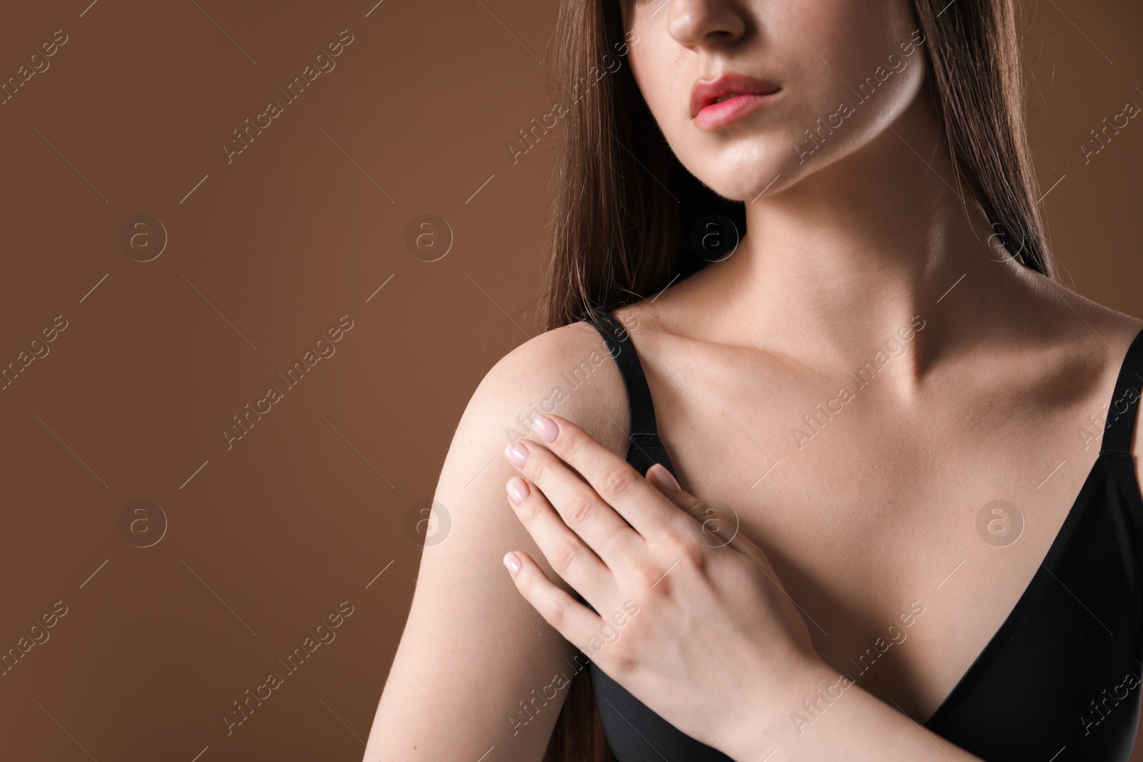 Woman with beautiful collarbone on brown background, closeup. Space for text Photo of Woman with beautiful collarbone on brown background, closeup. Space for text
