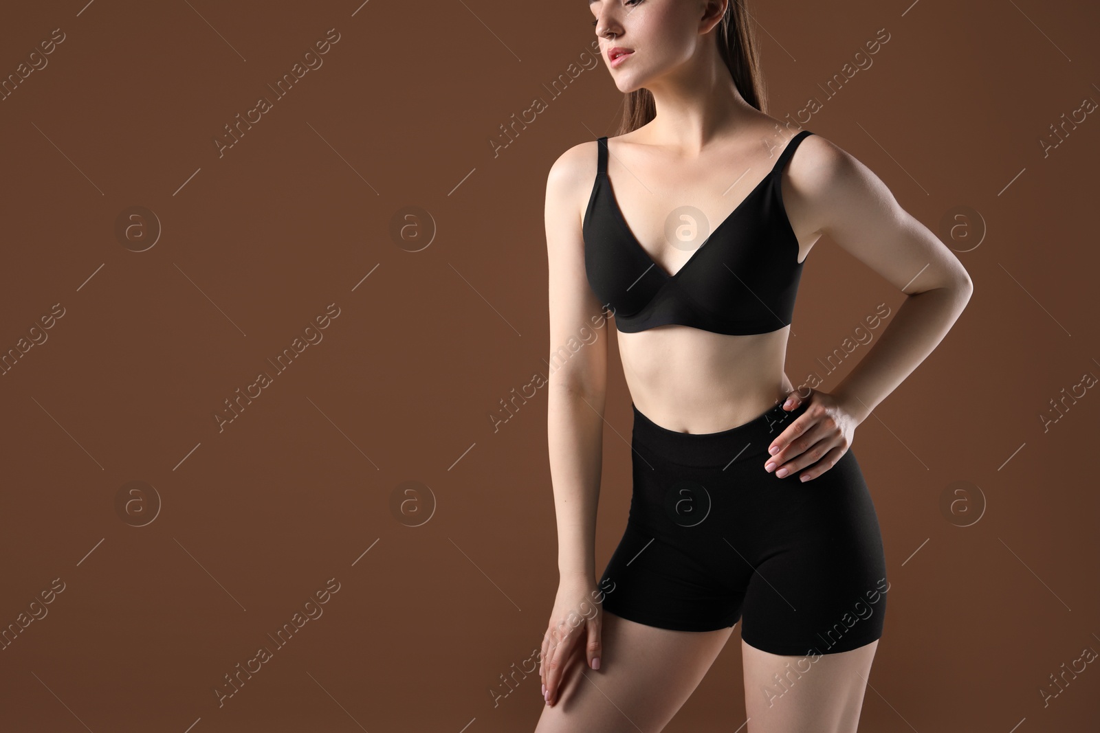 Woman with beautiful body on brown background, closeup. Space for text Photo of Woman with beautiful body on brown background, closeup. Space for text
