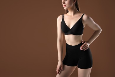 Photo of Woman with beautiful body on brown background, closeup. Space for text