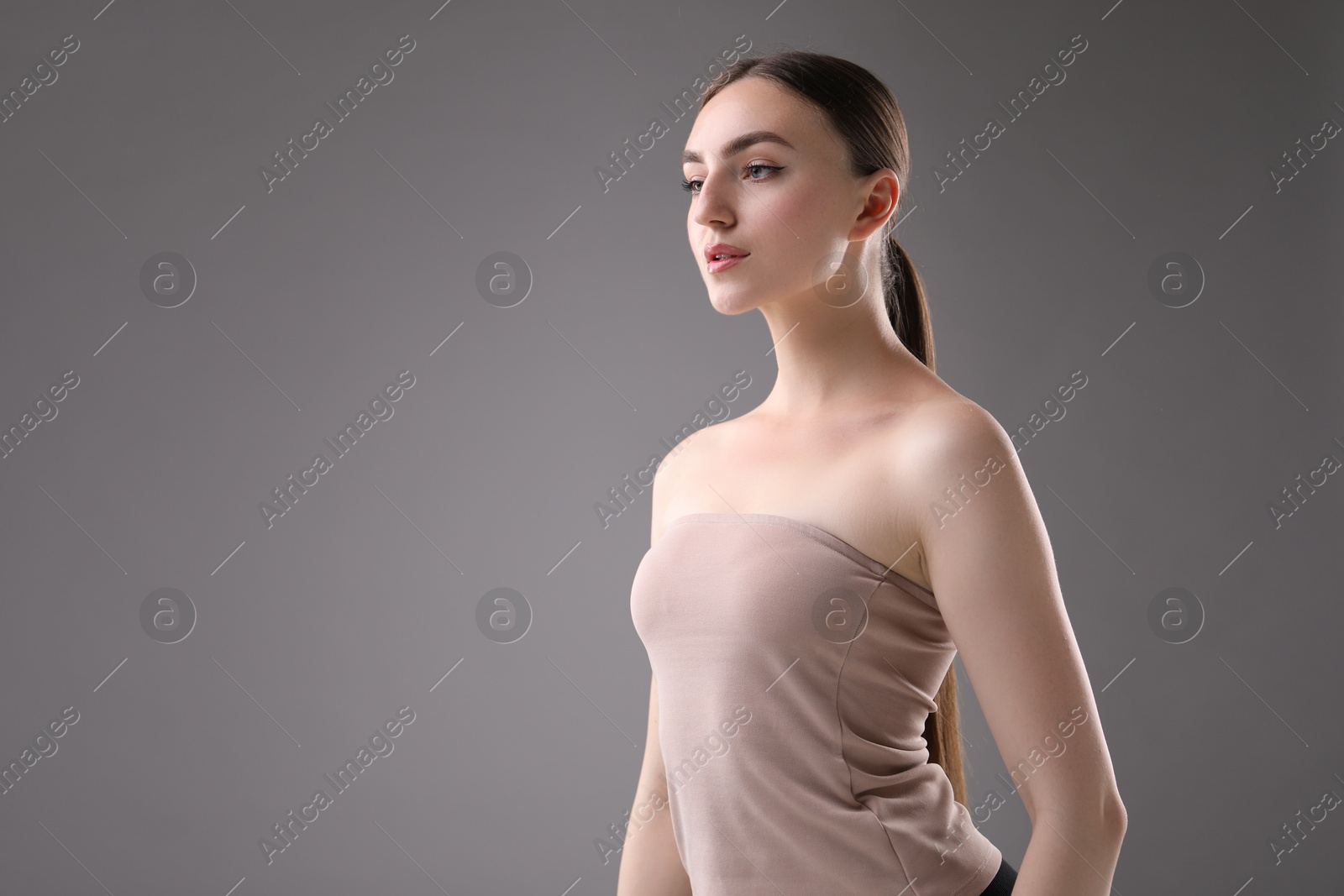 Portrait of beautiful woman on grey background. Space for text Photo of Portrait of beautiful woman on grey background. Space for text