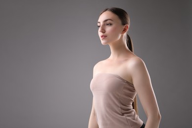 Photo of Portrait of beautiful woman on grey background. Space for text