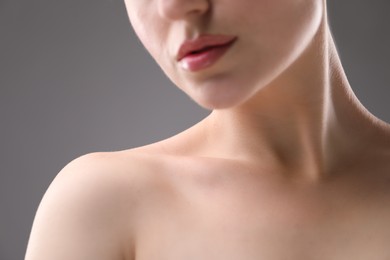 Photo of Woman with beautiful collarbones and neck on grey background, closeup
