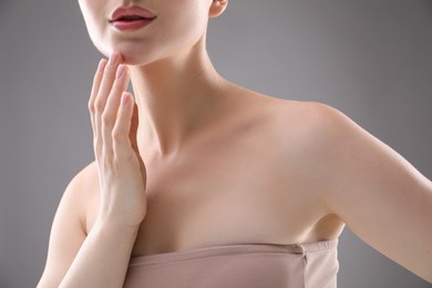 Photo of Woman with beautiful collarbones and neck on grey background, closeup